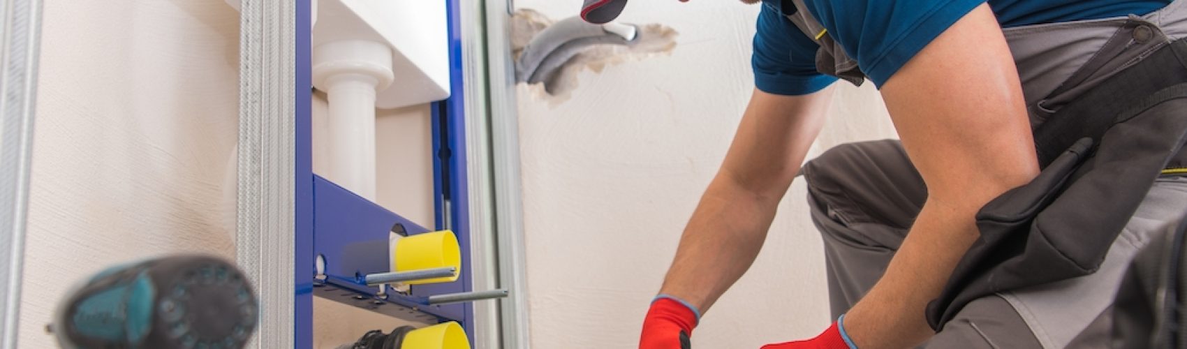 Caucasian Sanitary Plumbing Installer in His 30s Installing Bathroom Equipment.